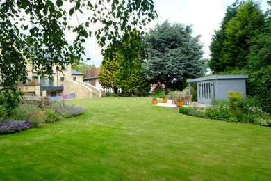 Großer Moderner Garten im Sommer, hinter dem Haus mit direkter Sonneneinstrahlung und Natursteinplatten in Sonstige