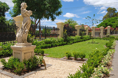 Modelo de jardín tradicional grande en patio delantero con jardín francés