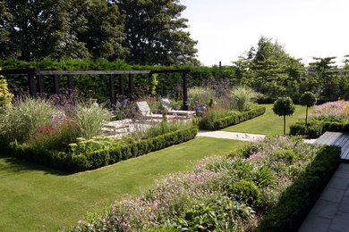 This is an example of a large traditional partial sun backyard stone formal garden in Berkshire.