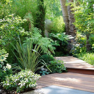 Photo of a large world-inspired back formal partial sun garden in London with decking and a garden path.