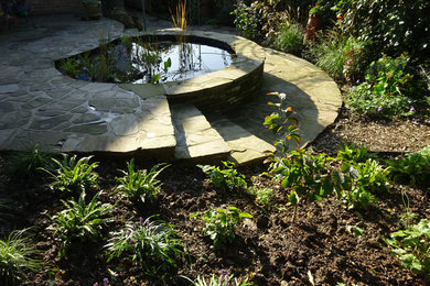 Diseño de jardín retro de tamaño medio en patio trasero con estanque, exposición parcial al sol y adoquines de piedra natural