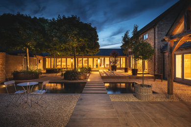 This is an example of a small contemporary courtyard formal full sun garden for summer in Oxfordshire with a waterfall.