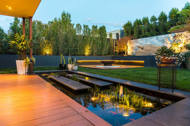 Exemple d'un jardin à la française arrière asiatique de taille moyenne et l'automne avec un foyer extérieur, une exposition ensoleillée et une terrasse en bois.