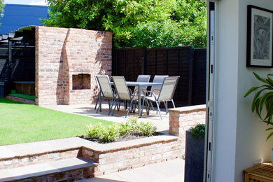 Design ideas for a medium sized modern back garden in Manchester with natural stone paving.
