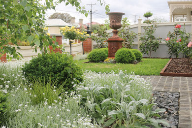 Imagen de jardín contemporáneo de tamaño medio en primavera en patio delantero con jardín francés, exposición total al sol y gravilla