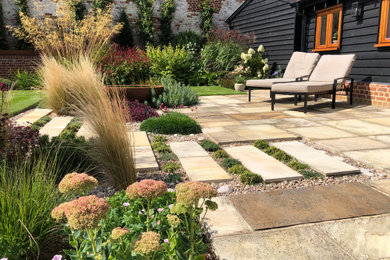 Inspiration for a medium sized contemporary back full sun garden in Hertfordshire with natural stone paving.