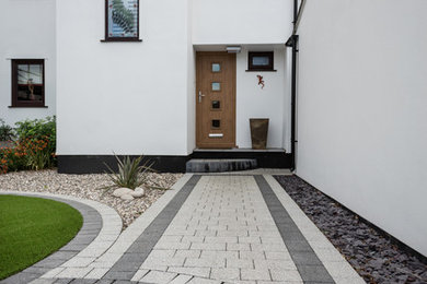 Inspiration för moderna trädgårdar, med en trädgårdsgång och marksten i betong