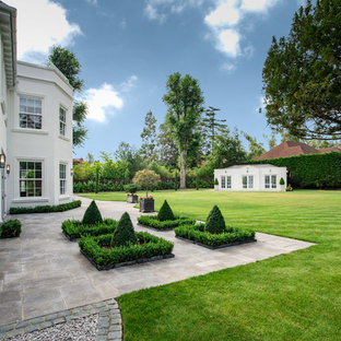 This is an example of a traditional back full sun garden in Buckinghamshire with natural stone paving.