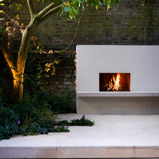 Kleiner, Halbschattiger Moderner Garten hinter dem Haus mit Kamin und Dielen in London