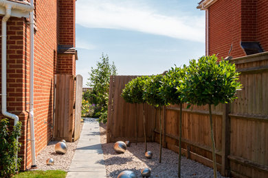 Diseño de camino de jardín contemporáneo de tamaño medio en patio delantero con exposición total al sol y gravilla