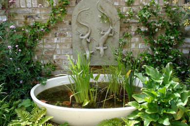 Modelo de jardín tradicional pequeño en patio con estanque, exposición parcial al sol y adoquines de ladrillo