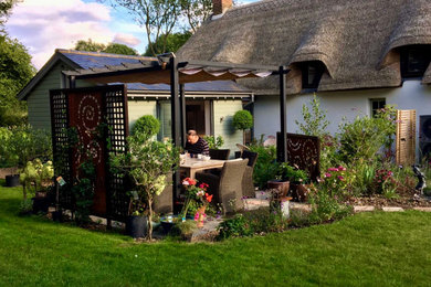 Diseño de jardín de estilo de casa de campo grande en verano en patio trasero con exposición total al sol y adoquines de hormigón
