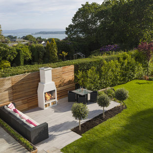 Geometrischer, Großer Moderner Garten im Sommer mit Kamin, direkter Sonneneinstrahlung und Betonplatten in Glasgow