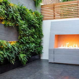 Kleines, Schattiges Modernes Garten im Innenhof im Sommer mit Kamin und Natursteinplatten in London