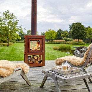 Geometrischer, Mittelgroßer Moderner Garten im Frühling, hinter dem Haus mit Kamin, direkter Sonneneinstrahlung und Dielen in Sonstige