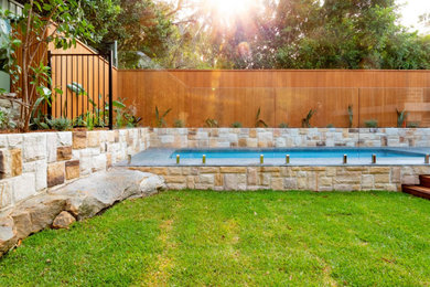 Inspiration pour un jardin arrière design avec des solutions pour vis-à-vis et une terrasse en bois.