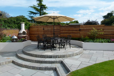 Idées déco pour une terrasse contemporaine de taille moyenne avec des pavés en pierre naturelle.