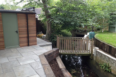 Kleiner, Halbschattiger Moderner Hanggarten im Sommer mit Natursteinplatten in London