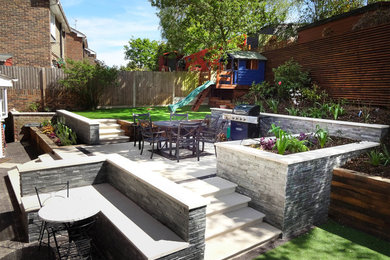 Design ideas for a medium sized contemporary back formal partial sun garden for summer in Kent with natural stone paving.