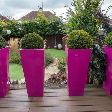 Pink tall tapered planters divide the garden