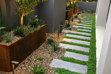 Inspiration för mellanstora moderna trädgårdar i delvis sol, med en trädgårdsgång och marksten i betong