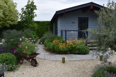 This is an example of a medium sized modern back full sun garden for summer in Dorset with gravel.