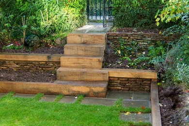 Photo of a contemporary garden in Other with a retaining wall and natural stone paving.