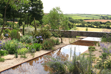 Imagen de jardín rústico extra grande en ladera con fuente, exposición parcial al sol y gravilla