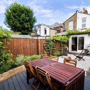 Photo of a small classic back formal full sun garden for spring in Other with gravel and a potted garden.