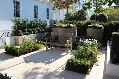 Photo of a medium sized contemporary front garden in London with a garden path and natural stone paving.