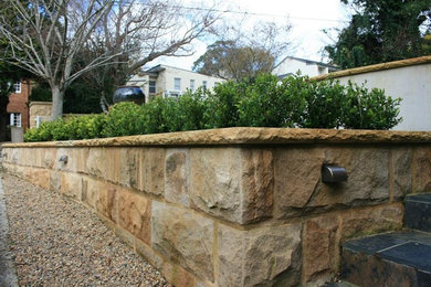 Photo of a classic front garden in Sydney with a retaining wall.