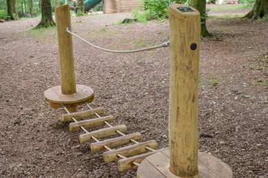 This is an example of a small rustic back partial sun garden for summer in Hampshire with a climbing frame and mulch.