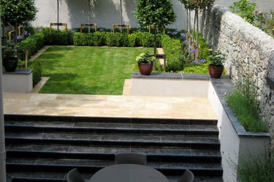 Small back formal partial sun garden for summer in Dublin with natural stone paving.