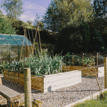 Raised beds and glasshouse in the kitchen garden