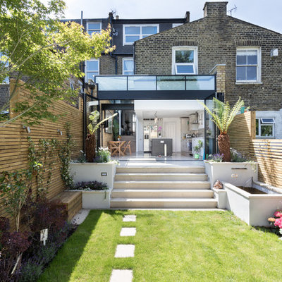 Photo of a mid-sized contemporary full sun backyard stone formal garden in London for summer.