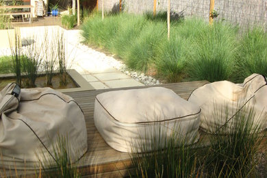 Ejemplo de jardín de secano actual pequeño en primavera con fuente, exposición total al sol y adoquines de piedra natural