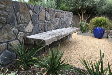 This is an example of a large shabby-chic style back xeriscape full sun garden for summer in Canberra - Queanbeyan with gravel.