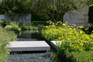 Exempel på en modern trädgård, med naturstensplattor