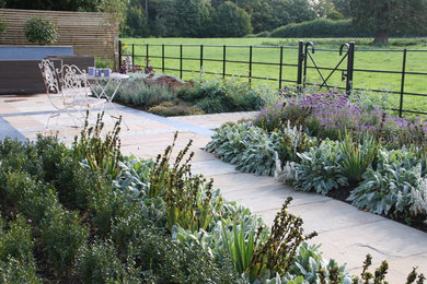 Contemporary garden in Other with natural stone paving.
