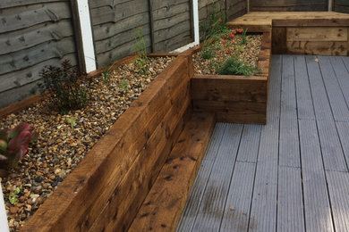 Design ideas for a small nautical courtyard xeriscape partial sun garden in Sussex with a raised bed and decking.
