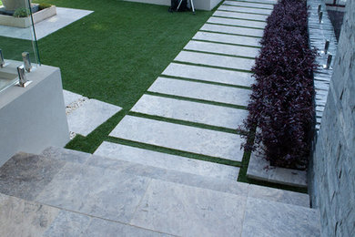 Imagen de jardín contemporáneo grande en patio delantero con jardín francés, exposición parcial al sol y adoquines de piedra natural