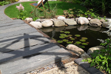 Slatewood beams and footbridge over a water feature