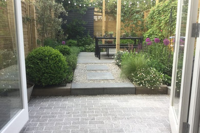 Inspiration for a small contemporary back garden in London with natural stone paving.