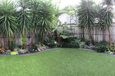 Foto de jardín exótico de tamaño medio en verano en patio trasero con jardín francés, jardín de macetas y exposición parcial al sol