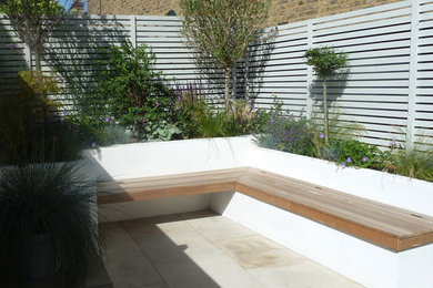 Small contemporary back garden in London with a water feature.