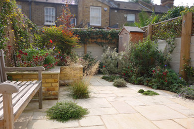 Photo of a small classic back partial sun garden for autumn in London with natural stone paving.