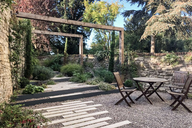 Foto di un piccolo giardino formale stile rurale esposto a mezz'ombra dietro casa in estate con ghiaia