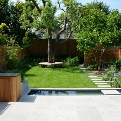 Design ideas for a mid-sized contemporary full sun backyard stone landscaping in London for summer.