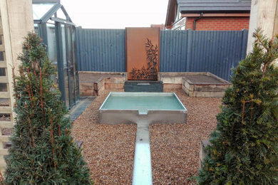 Inspiration for a large contemporary back formal full sun garden in Other with a water feature and natural stone paving.