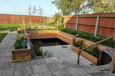 他の地域にある高級な広いコンテンポラリースタイルのおしゃれな裏庭 (池、日向、天然石敷き) の写真